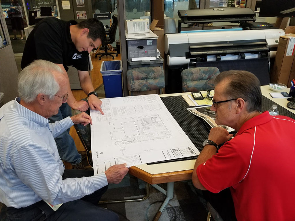 Mike Cassata (Cecil Field POW/MIA Memorial), Pat Geer and Jeff Strickland (Geer Services, Inc.) view the newly released plans and specifications provided by Prosser, Inc.